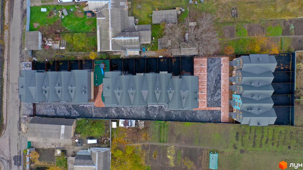 Таунхауси New Smart 13 з сірими дахами та блакитними фасадами, поруч парковка та зелена зона.