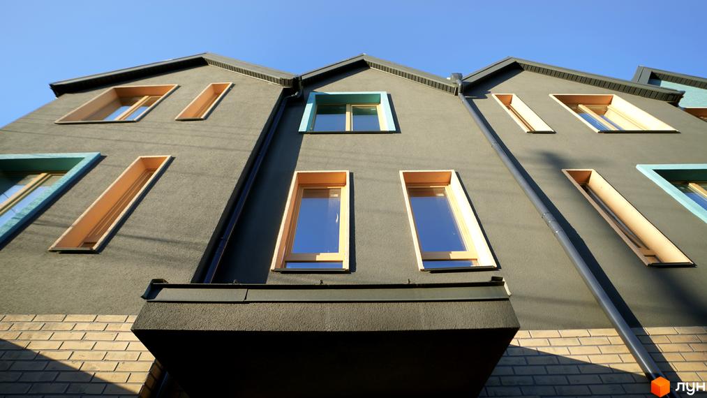 Фасад житлового комплексу New Smart 13 з незвичайними вікнами та цегляною кладкою. Сучасна архітектура та дизайн новобудови.