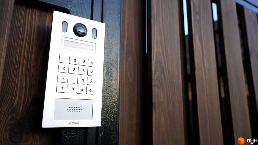 Відеодомофон на дерев'яному паркані таунхаусів New Smart 13. Сучасний дизайн та функціональність для вашого будинку.