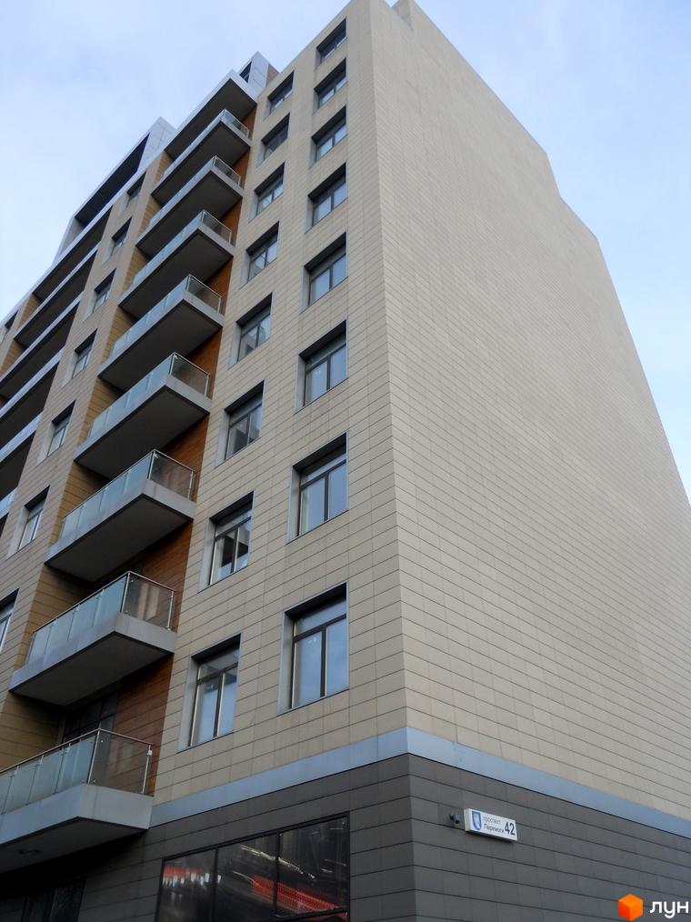 Житловий комплекс Crystal Park зі світло-бежевим фасадом та темним цоколем. Будівля має балкони зі скляними огорожами та табличку проспект Перемоги 42.