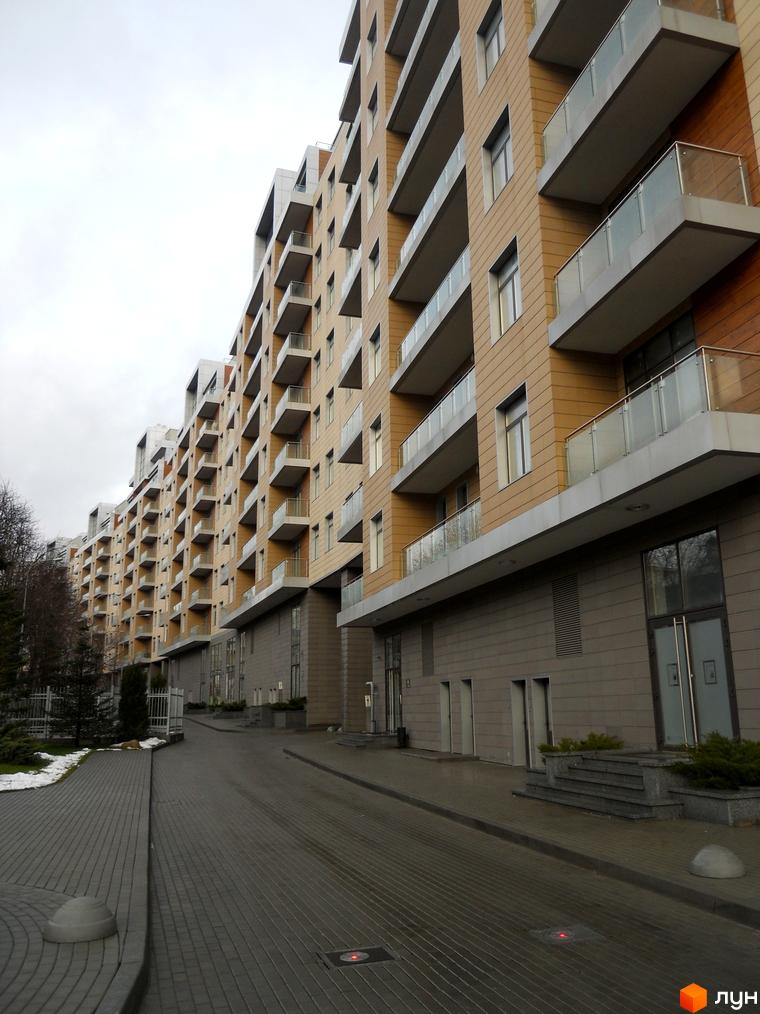 Житловий комплекс Crystal Park з балконами та сучасною фасадною обробкою. Прибудинкова територія з доріжками та зеленими насадженнями.