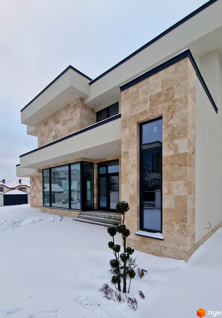 Зображення фасаду та прибудинкової території Котеджного містечка Riviera City Park. Двоповерховий будинок з великими вікнами та озелененням.