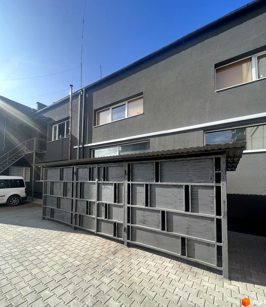 Зовнішній вигляд будинку Житлового комплексу City Line з сірими стінами та металевою конструкцією на передньому плані. Блакитне небо на задньому фоні.