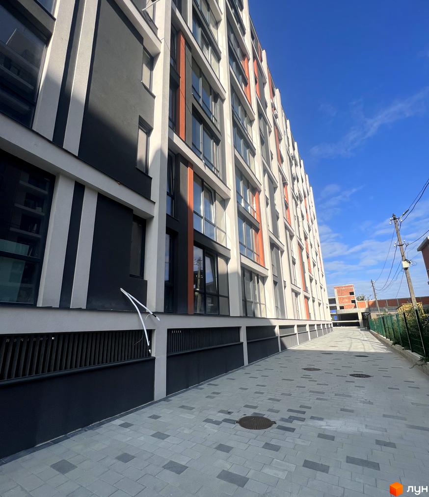 Зовнішній вигляд будинку Житлового комплексу City Line з прибудинковою територією. Багатоповерхова будівля з тротуарною доріжкою.