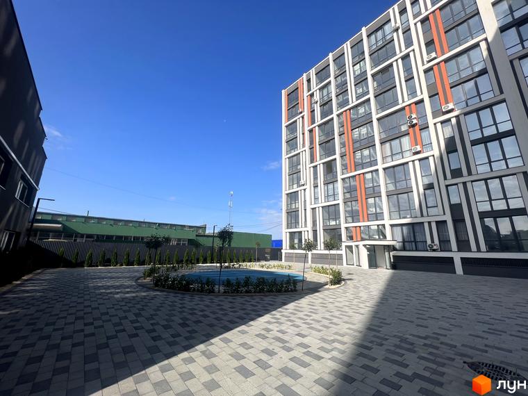 Зовнішній вигляд багатоповерхового будинку в Житловому комплексі City Line. На території розміщено басейн та висаджені декоративні рослини.