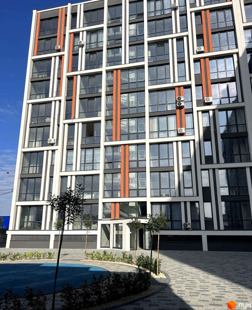 Житловий комплекс City Line: багатоповерховий будинок з біло-сірим фасадом, помаранчевими вертикальними смугами. Двір з бруківкою та зеленими насадженнями.