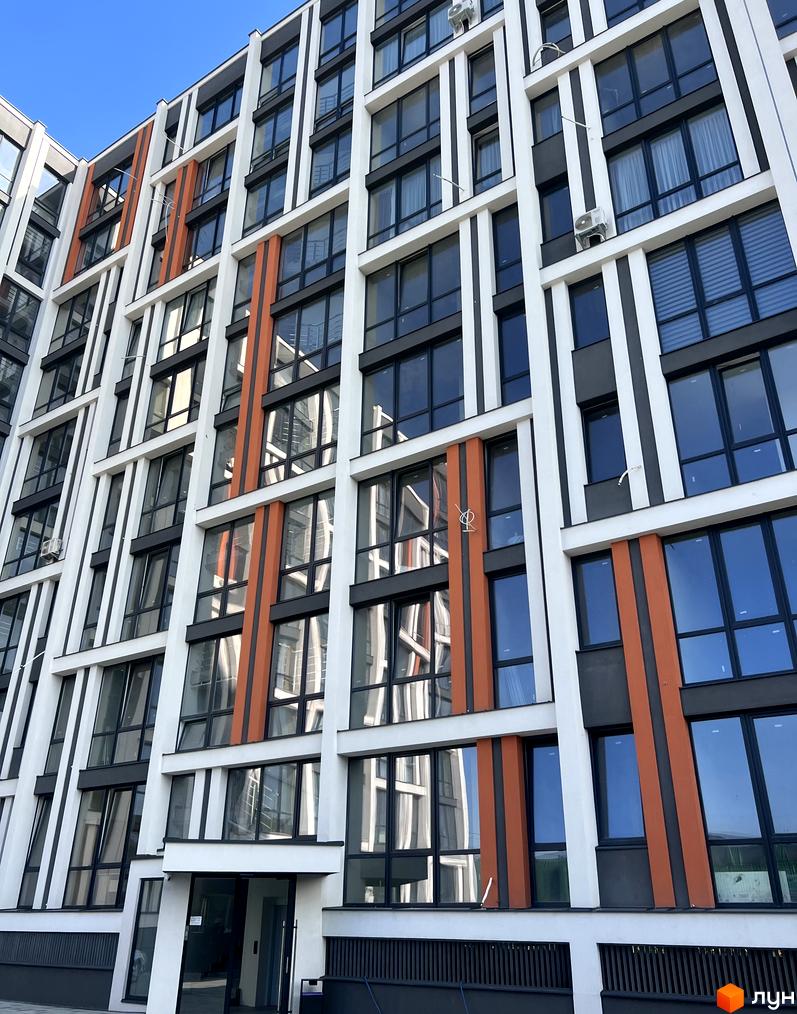 Житловий комплекс City Line: багатоповерховий будинок з білим, темно-сірим та помаранчевим фасадом, великими вікнами та вхідною групою.