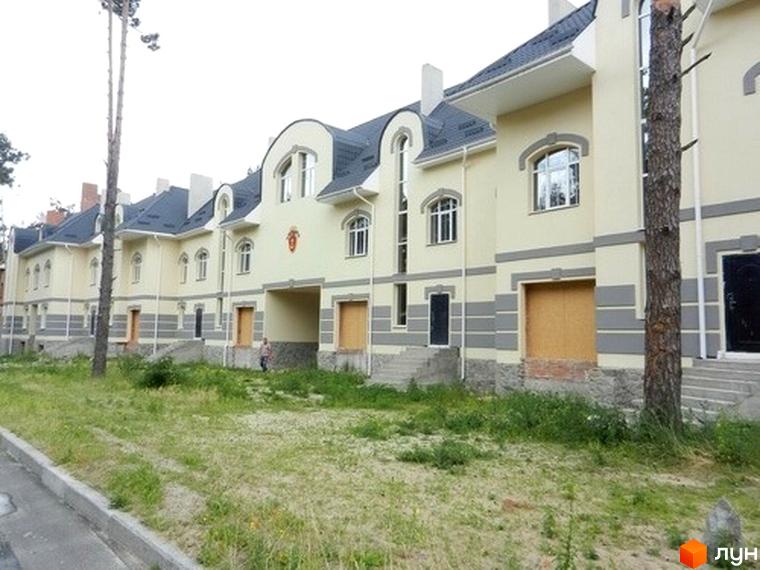 Зовнішній вигляд котеджного комплексу КМ Сосновий бір з прибудинковою територією, обрамленою зеленню.