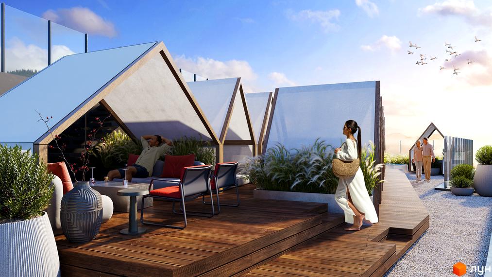 Апарт-комплекс Mountain Residence. Тераса з дерев'яним настилом, зручними меблями та зеленню. На задньому плані пара прогулюється біля басейну.