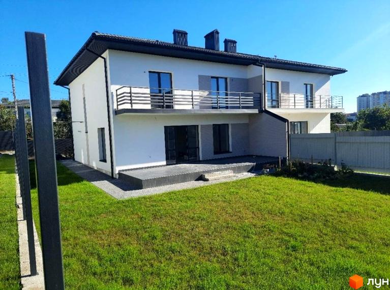 Котеджне містечко ЗУБРА ETALON: двоповерховий будинок з білими стінами, темним дахом та балконами. Прибудинкова територія з газоном і вимощеною терасою.