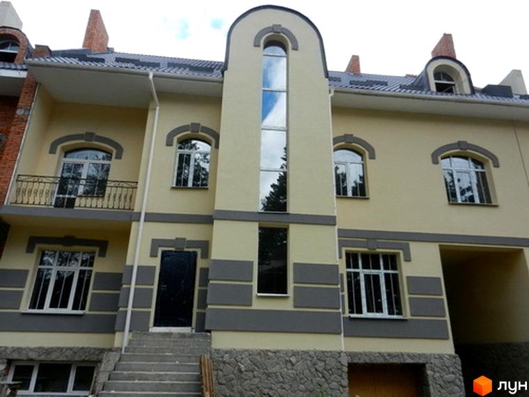 Зовнішній вигляд Котеджного містечка Сосновий бір. Двоповерховий будинок з великими вікнами та сірим оздобленням фасаду.