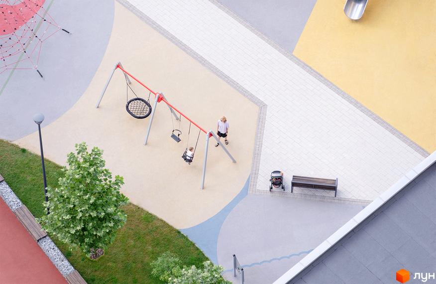 Вид зверху на територію житлового комплексу Русанівська Гавань: дитячий майданчик з гойдалками, ландшафтний дизайн та пішохідні зони.