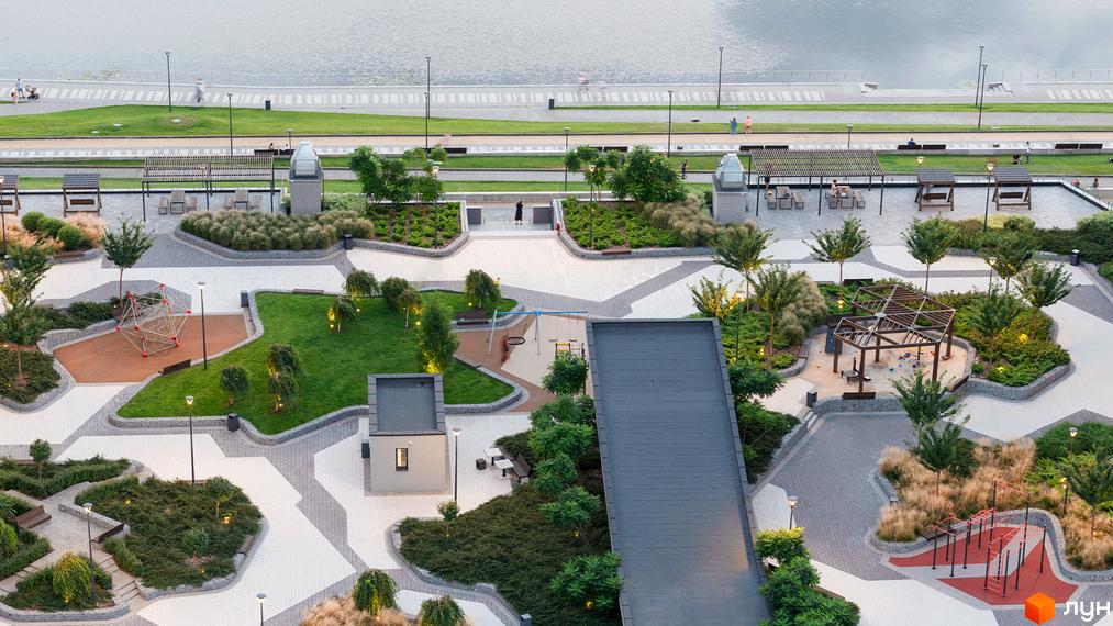 Благоустрій житлового комплексу Русанівська Гавань: дитячі майданчики, спортивні зони, зелені насадження та прогулянкові алеї біля водойми.