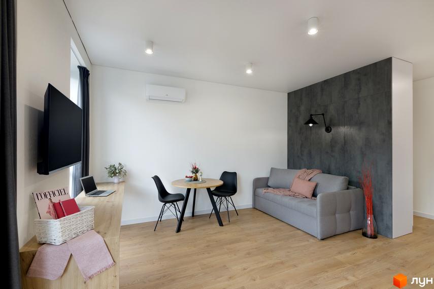Дизайн інтер'єру студії в Coliving ONE Nivki: диван, стіл, стільці та телевізор на стіні. Опис житлового комплексу для просування сайту новобудов.