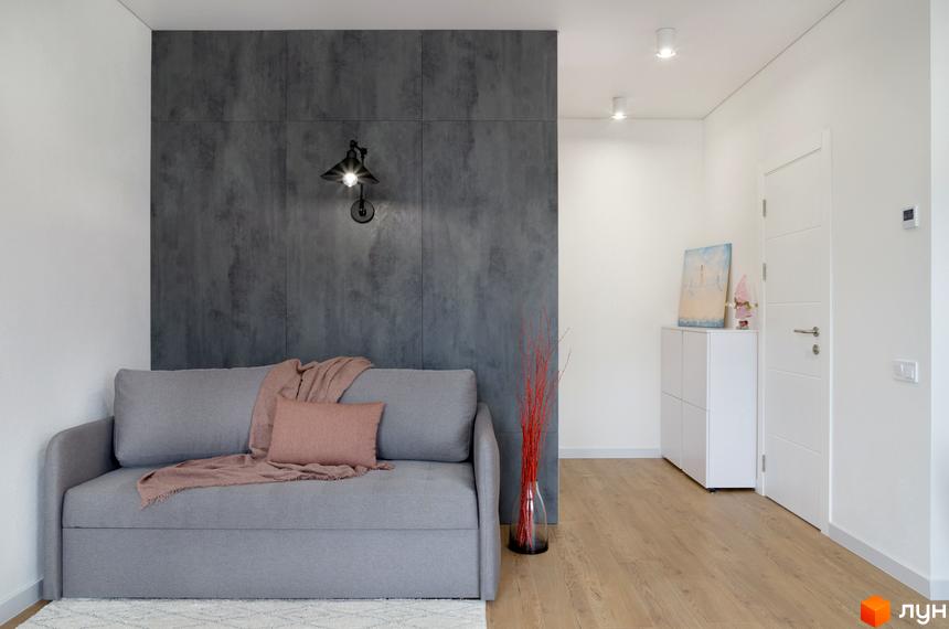 Інтер'єр квартири в Coliving ONE Nivki з сірим диваном та декоративною стіною. Сучасний дизайн житлового комплексу.