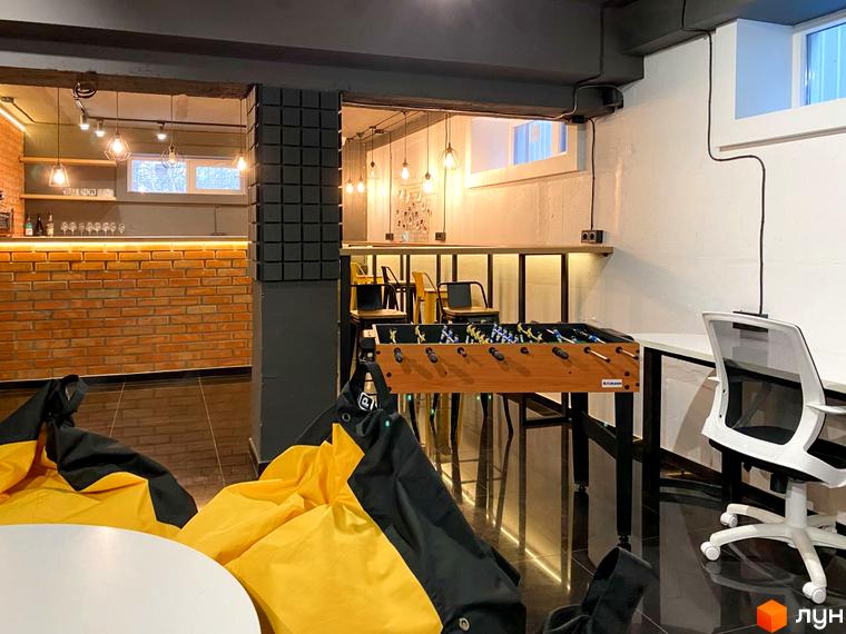 Зона відпочинку в Coliving ONE Nivki з настільним футболом та м'якими кріслами. Сучасний простір для дозвілля мешканців.