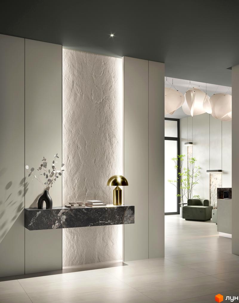 Просторий хол житлового комплексу N69 Residents з мармуровою консоллю, лампою та декором. За скляними дверима видно зелені рослини та меблі.