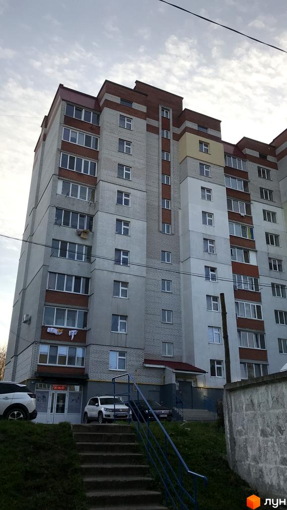 Житловий комплекс на вул. Ранкова, 2а. Вид на фасад будинку та прибудинкову територію з автомобілями і сходами.