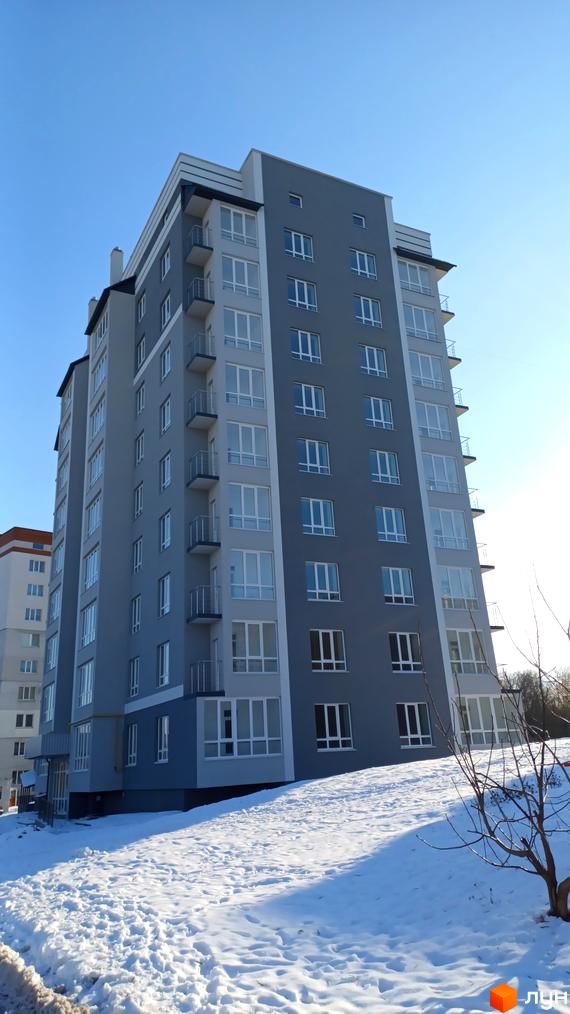 Житловий комплекс на вул. Ранкова, 2а, з сучасним фасадом та великими вікнами. Прибудинкова територія з засніженим ландшафтом.
