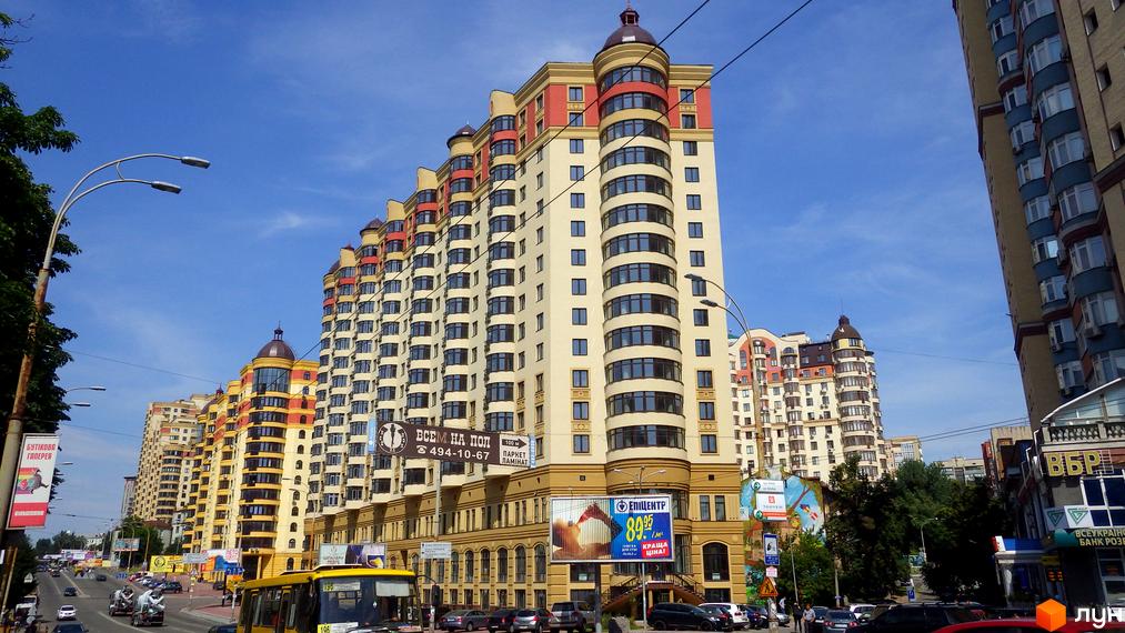 Житловий комплекс Златоустівський з яскравими фасадами та округлими вікнами, оточений прибудинковою територією та зеленими насадженнями.