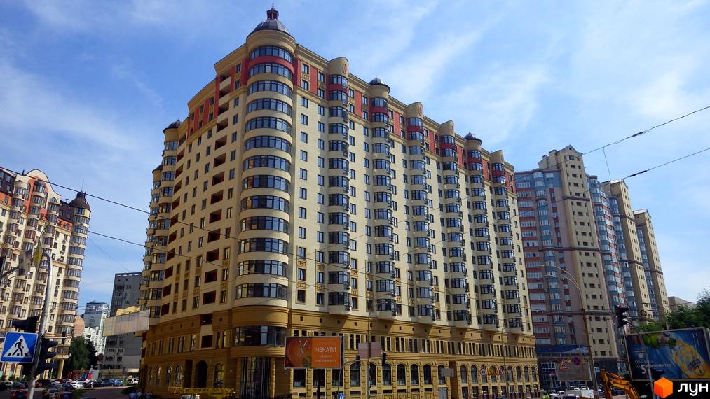 Зовнішній вигляд житлового комплексу Златоустівський з багатоповерховими будинками та вигнутими фасадами. Навколо будівлі видно міську інфраструктуру.