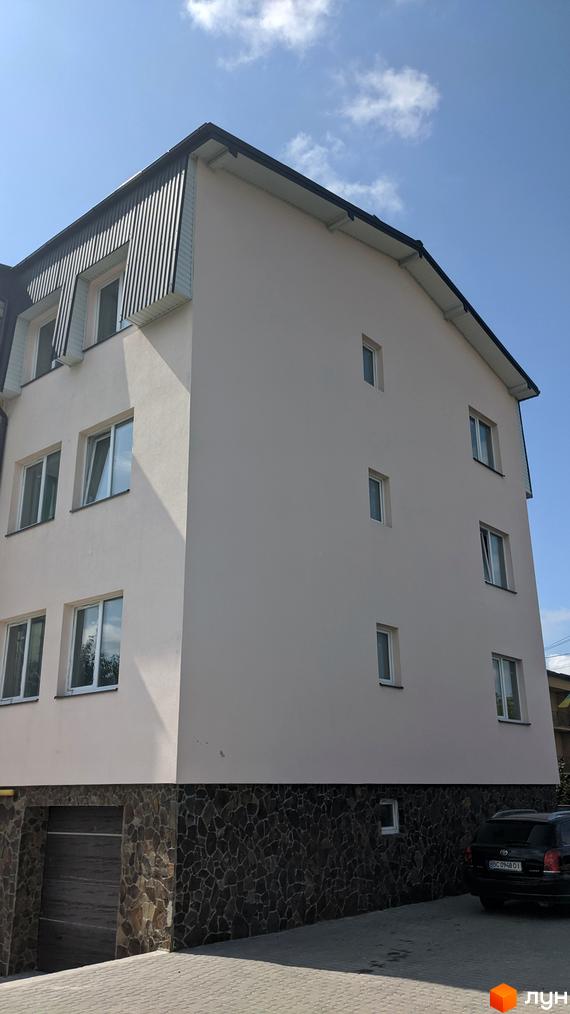 Зовнішній вигляд новобудови на вул. Наварійській, 29д, з кам'яною обробкою цоколя та прибудинковою територією.