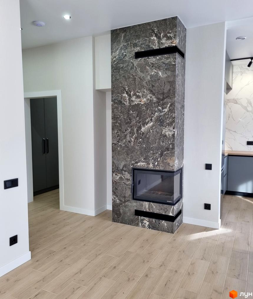 Інтер'єр квартири в КМ Сонячний з каміном та дерев'яною підлогою. Сучасний дизайн вітальні з акцентом на функціональність та комфорт.