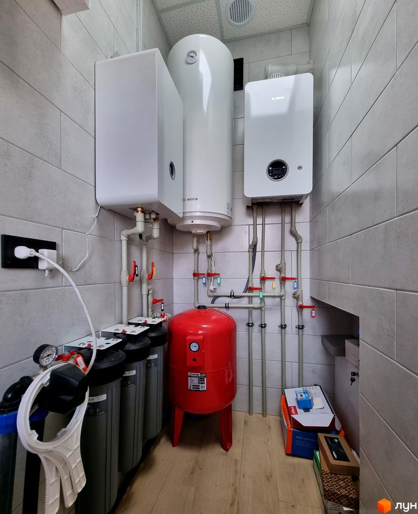 Котеджне містечко Сонячний: інженерні системи та обладнання в одному з будинків. Фото демонструє бойлер, систему фільтрації води та інше технічне оснащення.