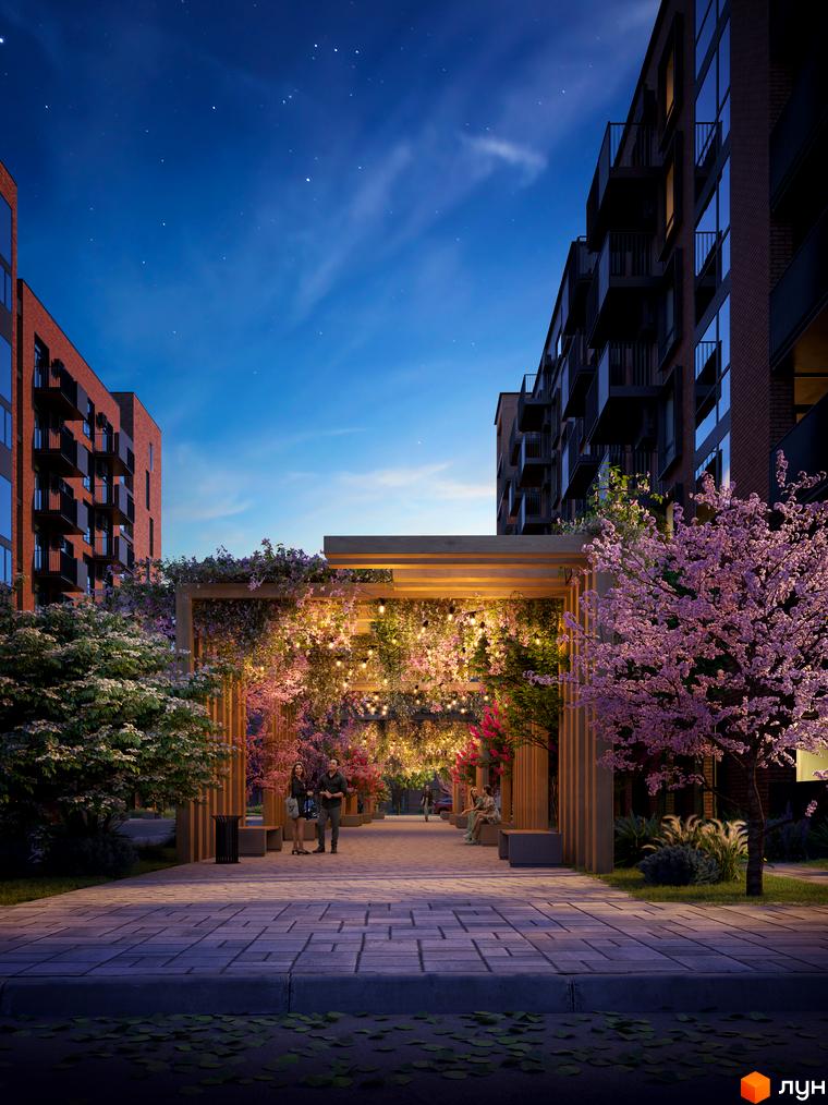 Житловий комплекс Royal Town. Нічний вид на сучасну новобудову з балконами та освітленим квітковим арковим проходом з людьми.