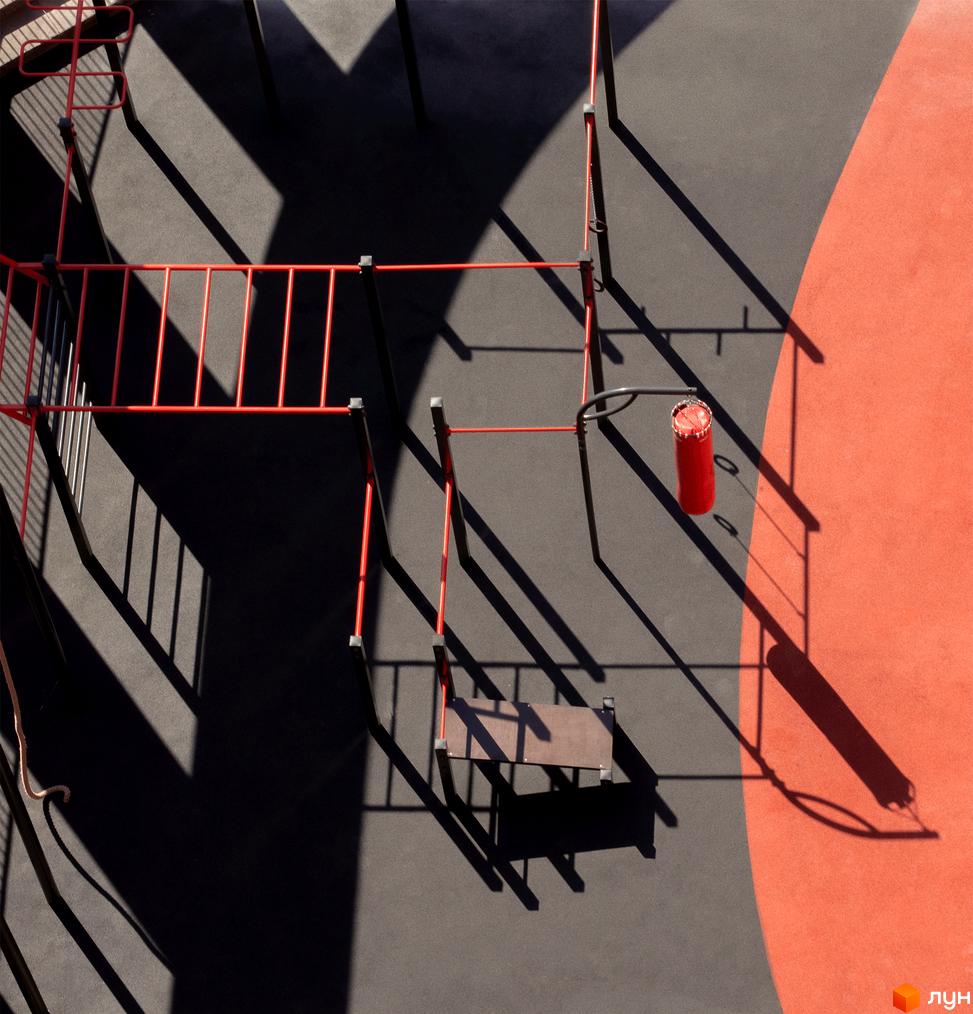 Прибудинкова територія житлового комплексу DOCK32: спортивний майданчик з червоними металевими конструкціями та яскравими тінями.