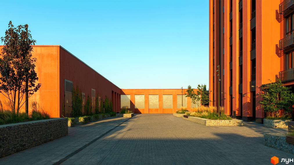 Житловий комплекс DOCK32 з будівлями теракотового кольору та темними вертикальними лініями. Прибудинкова територія має мощення, дерева та декоративні трави.