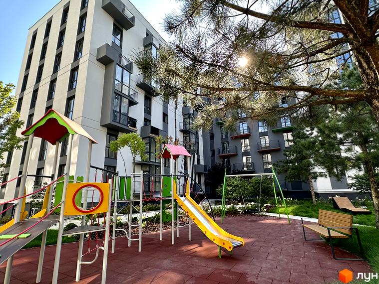 Висотна новобудова ЖК Проект Панорама з сучасним дитячим майданчиком та зоною відпочинку. Простора прибудинкова територія з зеленими насадженнями.