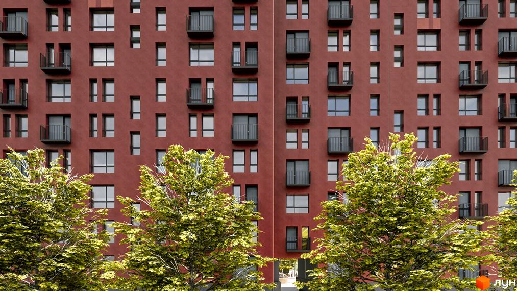 Фасад житлового комплексу Паркове містечко (7 черга) з червоної цегли та балконами. На передньому плані зелені дерева.