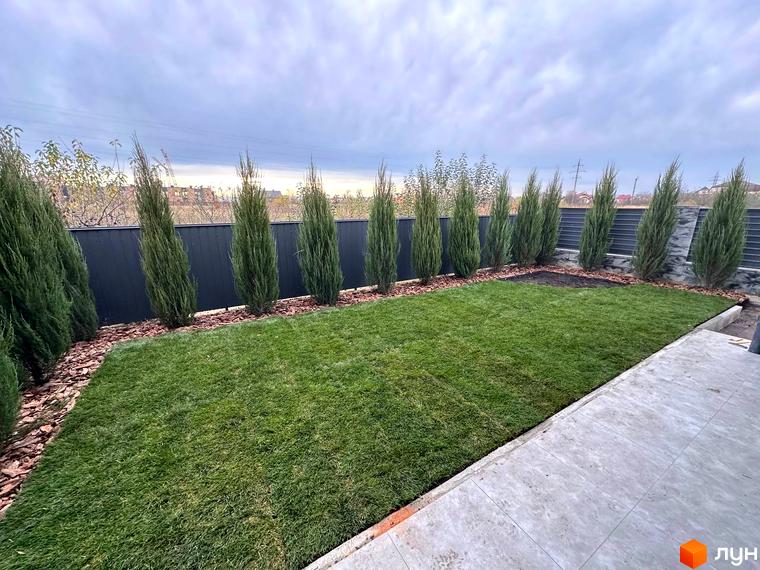 Таунхауси „Садовий Клуб“: зелений газон та доглянуті туї вздовж паркану створюють затишну прибудинкову територію. Ідеальне місце для життя та відпочинку.