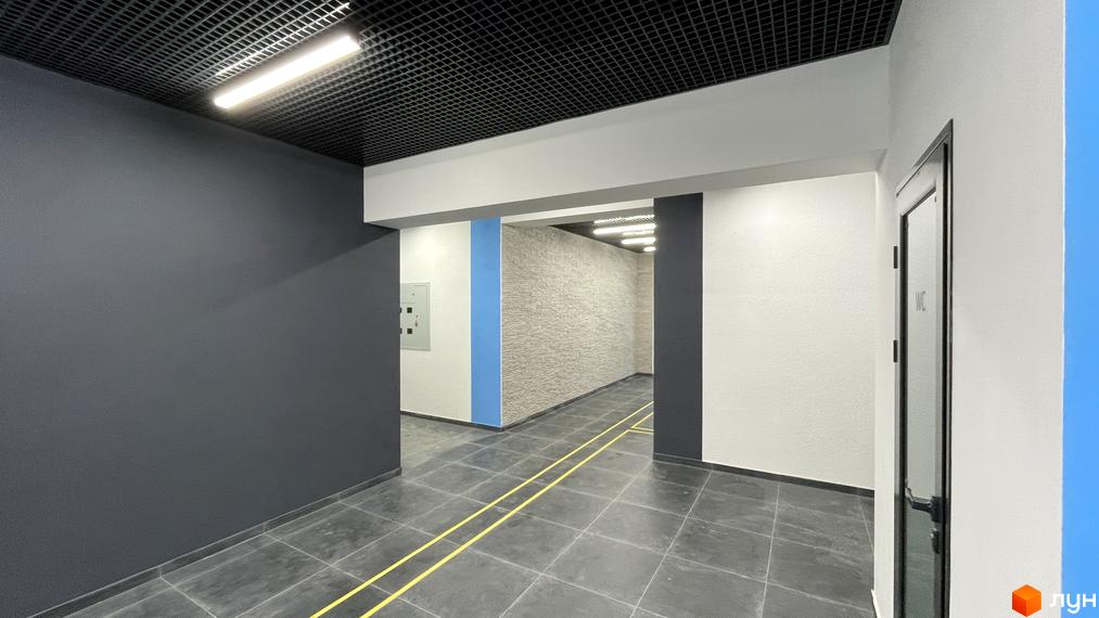 Фото внутрішнього інтер'єру Житлового комплексу One Family. Вигляд коридору з сірими стінами та плиткою на підлозі.