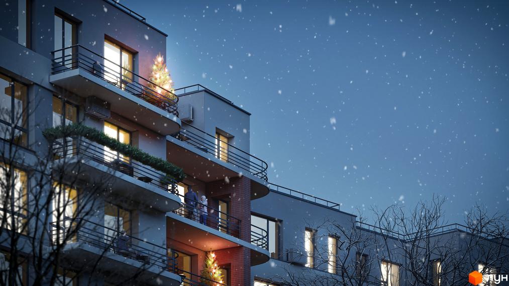 Багатоповерховий будинок Житлового комплексу РЕМ ввечері під снігопадом. На балконах видно різдвяні прикраси та освітлені вікна.