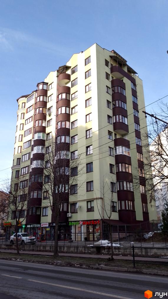 Новобудова на вул. Симоненка, 5а: багатоповерховий будинок світло-зеленого кольору з коричневими елементами. На першому поверсі магазини.