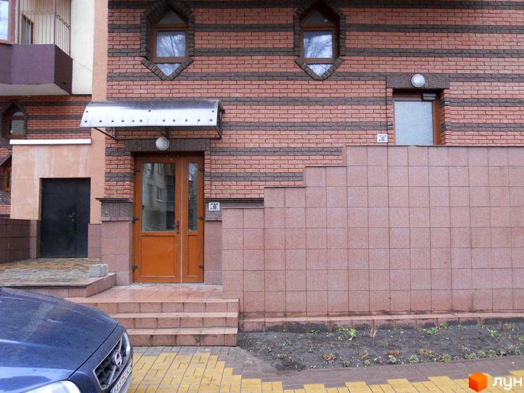 Житловий комплекс на вул. Коперника, 11. Вхідна зона з цегляною стіною та прибудинкова територія з плиткою.