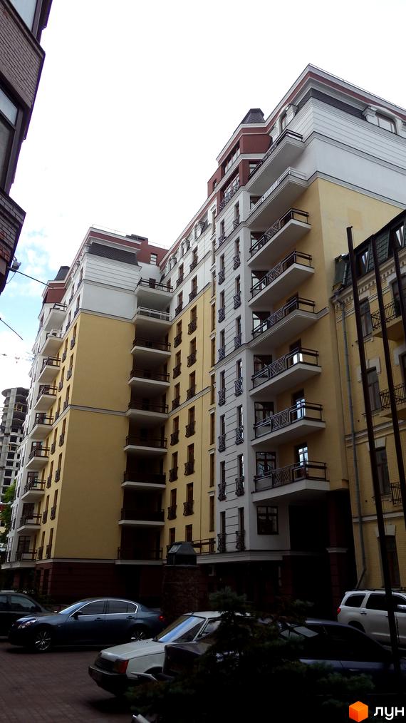 Житловий комплекс ARCH House - фасади будівель з балконами та вікнами, парковка з автомобілями.