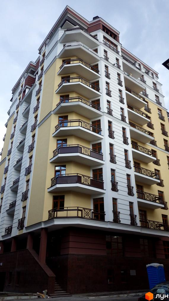 ARCH House - багатоповерховий житловий комплекс з балконами та панорамними вікнами. Фасад будинку оздоблений світлою штукатуркою та темними елементами.