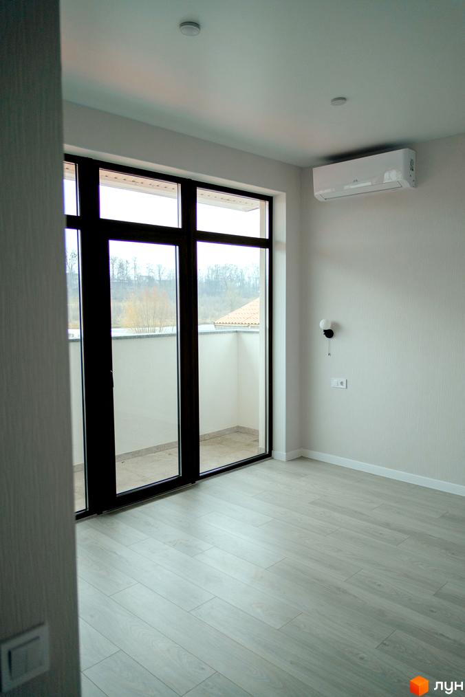 Інтер'єр квартири в КМ Little Italy Apartments з великими вікнами та виходом на балкон. Сучасний ремонт та світла підлога.