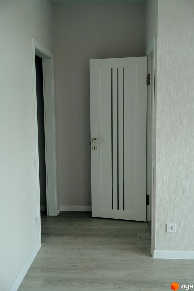 Інтер'єр квартири в житловому комплексі КМ Little Italy Apartments з білими дверима та сірою підлогою. Сучасний дизайн інтер'єру.