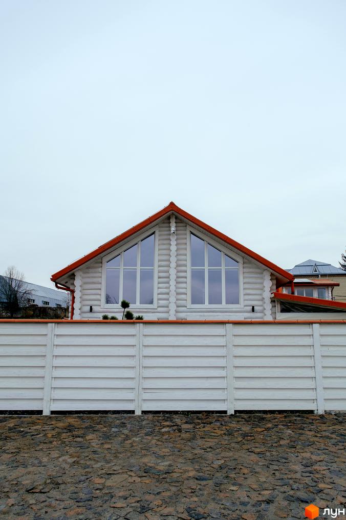 Котеджне містечко КМ Little Italy Apartments: двоповерховий будинок з червоним дахом та великими вікнами, огороджений білим парканом та вимощений бруківкою.