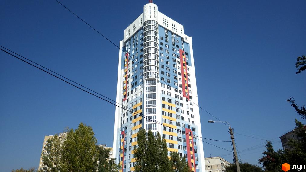 Житловий комплекс Артемівський - висотна новобудова з яскравим фасадом, що складається з блакитних, білих, жовтих та червоних секцій. Будинок має багато вікон та вигнуту центральну частину.