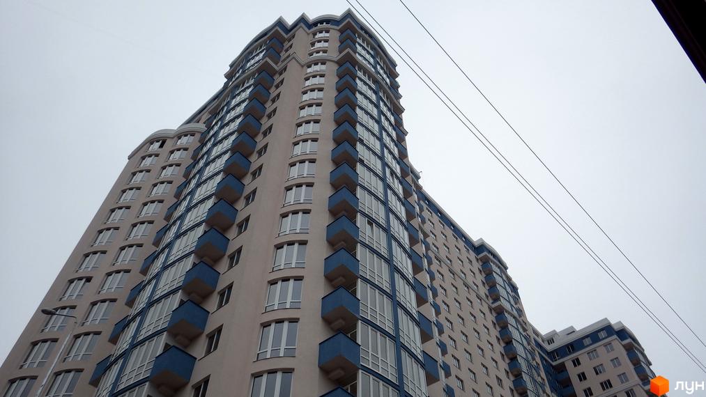 Фото фасаду багатоповерхового будинку Житлового комплексу Старокиївський. Вигляд з вулиці на новобудову з великими вікнами та балконами.
