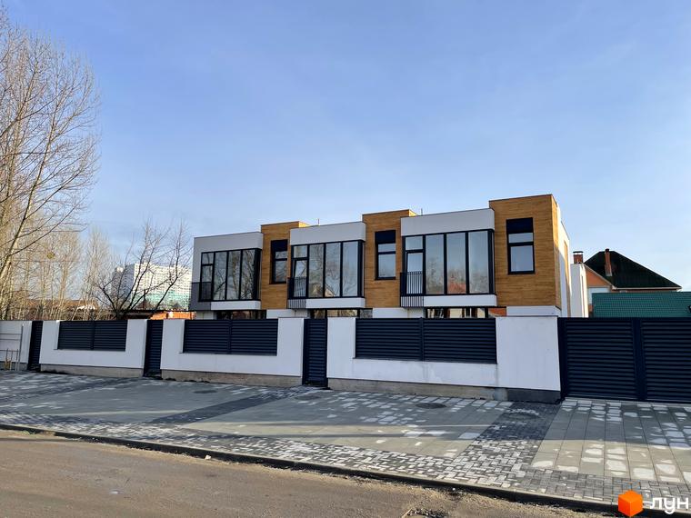 Таунхауси Gatne Country Club - це сучасні будинки з великими вікнами та дерев'яним оздобленням фасаду, розташовані за огородженою територією з бруківкою.