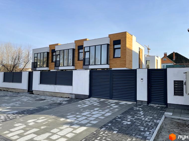 Таунхауси Gatne Country Club - фасади з дерев'яними елементами та великими вікнами, огороджена територія з бруківкою.