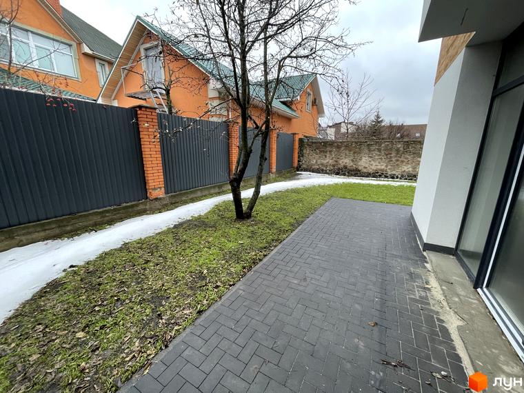 Таунхауси Gatne Country Club: фасади будинків з оранжевою штукатуркою та зелені дахи. Прибудинкова територія з бруківкою та огорожею.