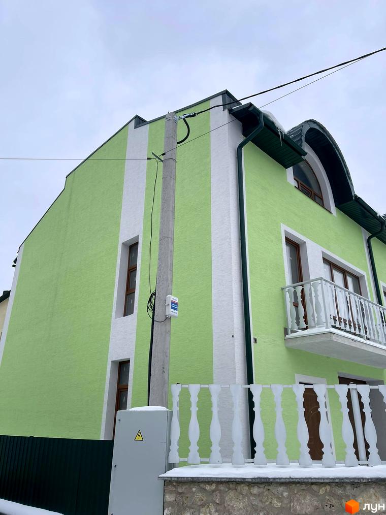 Зовнішній вигляд будинку Таунхауси „Гаї Гречинські“ з яскраво-зеленим фасадом та білими смугами. Навколо будинку видно паркан та елементи прибудинкової території.