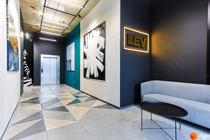 Холл житлового комплексу ARTHOUSE park з геометричною плиткою на підлозі, картинами та диваном для відпочинку. Просторий та світлий простір з елементами дизайну.